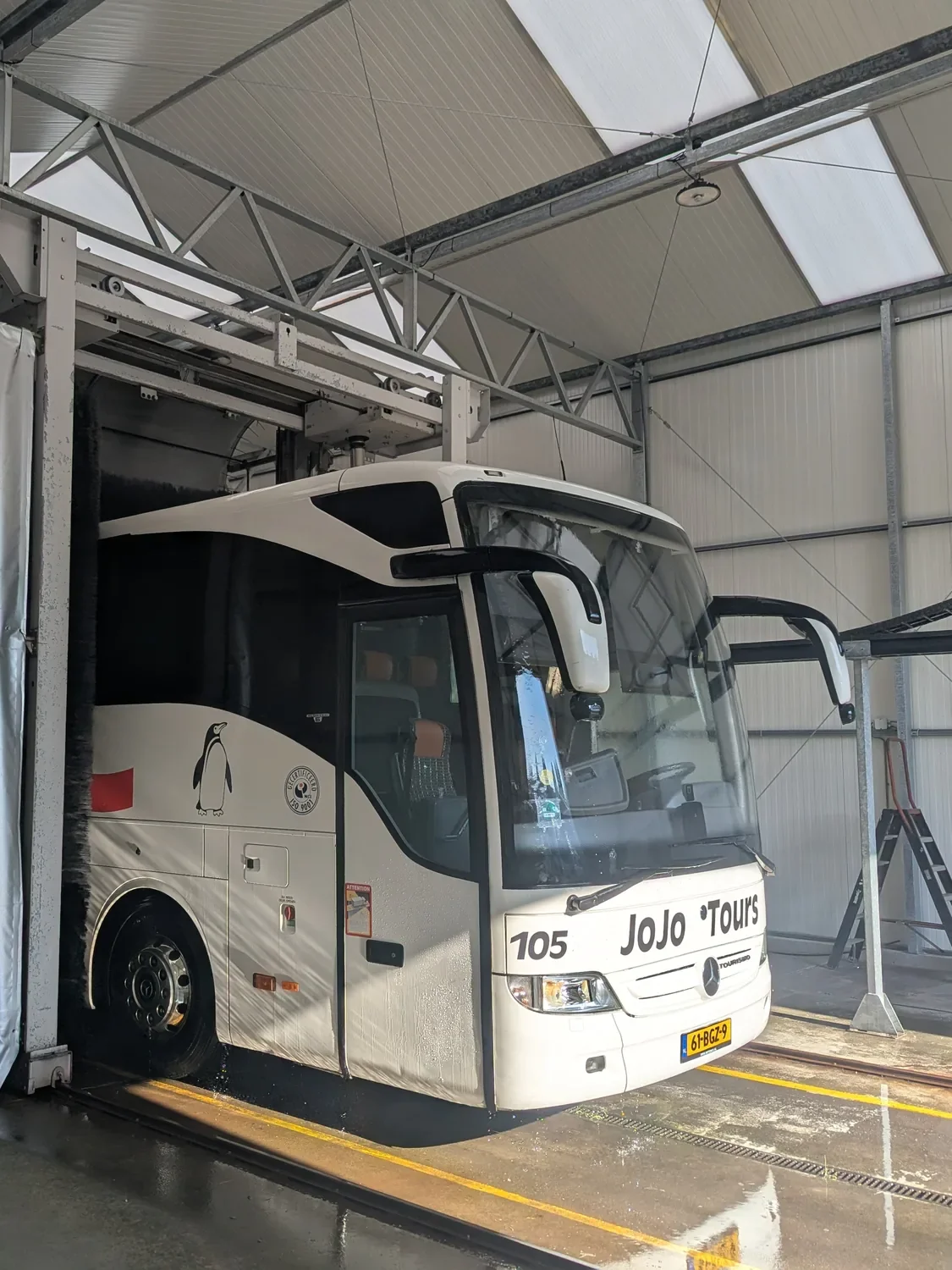 Touringcar van JoJo Tours in de wasstraat in Vlaardingen, vooraanzicht